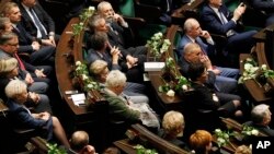 Poland's opposition lawmakers and senators with white roses, the symbol of their protest against the government policies, during a speech by President Andrzej Duda in parliament in Warsaw, Poland, Dec. 5, 2017. 