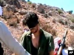 FILE - In this image taken from undated video posted to YouTube, American freelance journalist Austin Tice, who had been reporting for U.S. news organizations in Syria until his disappearance in August 2012, prays in Arabic and English while blindfolded in the presence of gunmen.