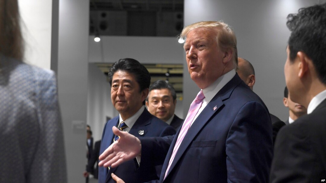 參加大阪20國集團峰會的美國總統特朗普和日本首相安倍晉三走在一起。(2019年6月28日) 