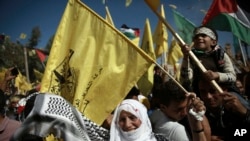 Palestinians wave national and yellow Fatah movement flags during a rally marking the 13th anniversary of the death of Fatah founder and Palestinian Authority leader Yasser Arafat, in Gaza City, Saturday, Nov. 11, 2017.