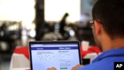 FILE - A man logs on to Facebook on his laptop at a restaurant in Brasilia, Brazil, Jan. 4, 2018. 