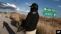 FILE - Police man a checkpoint in Janos, Chihuahua state, northern Mexico, Nov. 5, 2019.