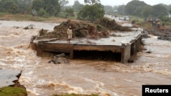 FILE - A man looks at a washed away bridge along Umvumvu river following Cyclone Idai in Chimanimani, Zimbabwe, March 18, 2019. 