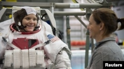 FILE - Astronaut Anne McClain, left, is seen during training at the Neutral Buoyancy Laboratory in Houston, Texas, Jan. 12, 2015. 