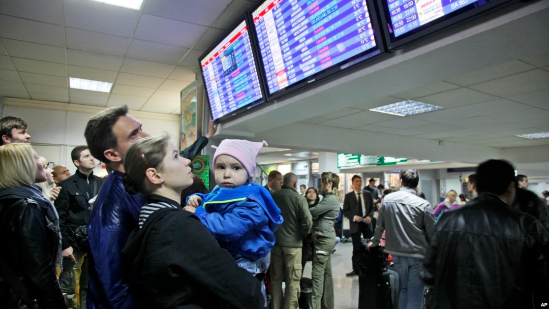 FILE - Travelers check a departures board at Borispol International Airport, near Kyiv, Ukraine.