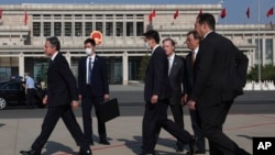 Menteri Luar Negeri Amerika Serikat Antony Blinken (kiri) berjalan bersama para stafnya saat tiba di Beijing, Minggu, 18 Juni 2023. (Foto: Leah Millis/Pool Photo via AP)