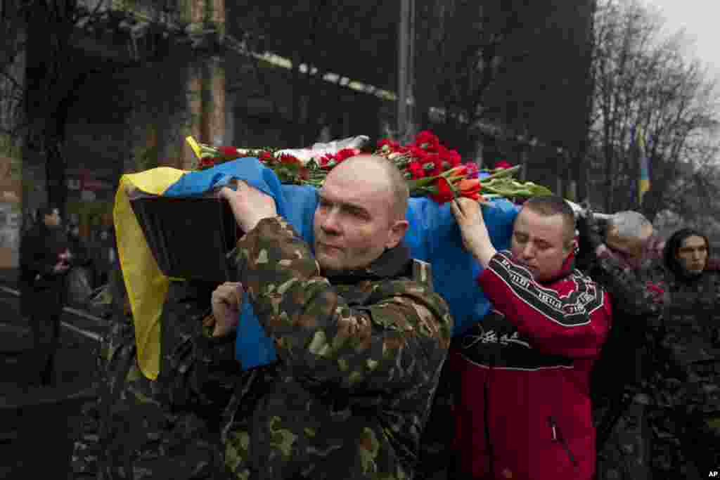 Pallbearers carry the coffin of a self defense volunteer who was shot and killed by an unknown assailant two days ago near Kyiv's Independence Square, March 6, 2014.