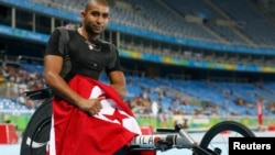 Le tunisien Walid Ktila fête sa victoire après avoir remporté la médaille d'or au 100 mètres hommes lors des Jeux paralympiques de Rio, Brésil, le 12 septembre 2016.