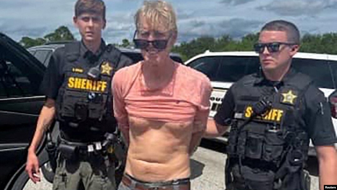 Ryan Wesley Routh, suspected of attempting to assassinate former President Donald Trump, stands handcuffed between two Martin County deputies after his arrest near Palm City, Florida, Sept. 15, 2024. (Martin County Sheriff's Office/Handout via Reuters)