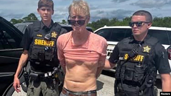 Ryan Wesley Routh, suspected of attempting to assassinate former President Donald Trump, stands handcuffed between two Martin County deputies after his arrest near Palm City, Florida, Sept. 15, 2024. (Martin County Sheriff's Office/Handout via Reuters)