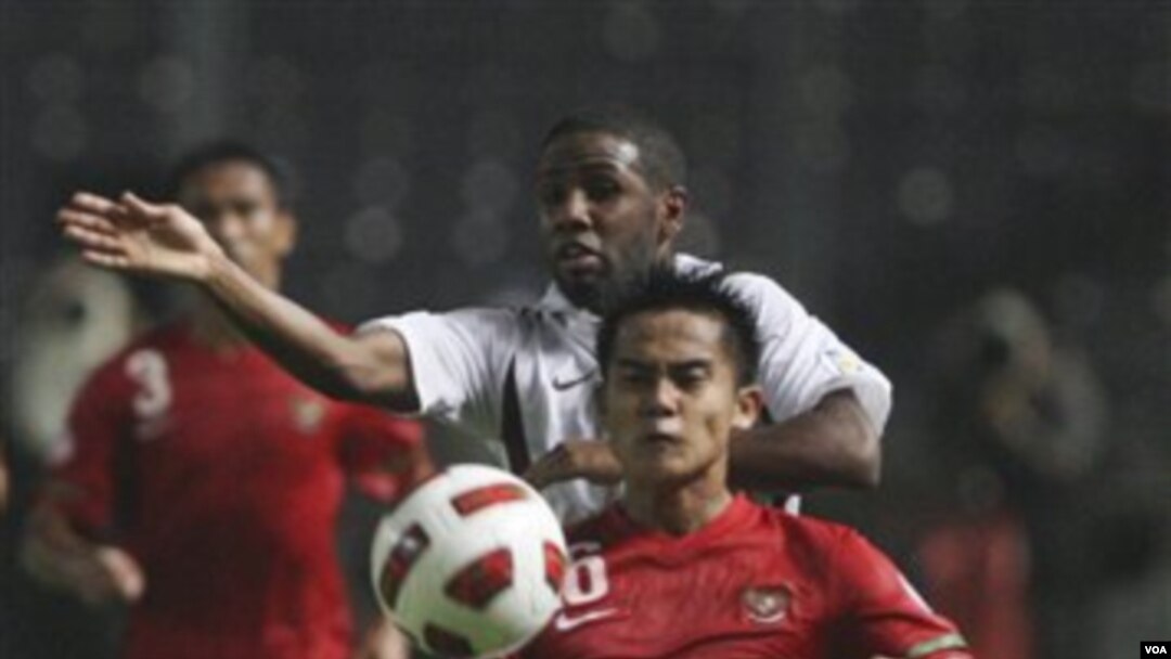 Muhamad Roby (depan) berebut bola dengan pemain Qatar, Khalfan Ibrahim, pada pertandingan Selasa malam (11/10) di Gelora Bung Karno, Jakarta.