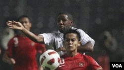 Muhamad Roby (depan) berebut bola dengan pemain Qatar, Khalfan Ibrahim, pada pertandingan Selasa malam (11/10) di Gelora Bung Karno, Jakarta.