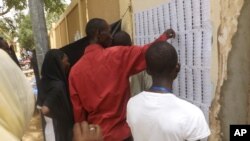 Voters look for their names before casting their ballots during elections in N'Djamena, Chad, Sunday, April 10, 2016.