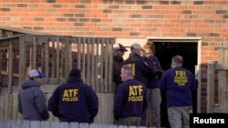 Law enforcement officers gather to investigate information arising the day after a downtown Nashville explosion, outside a duplex house in Antioch, Tennessee, Dec. 26, 2020.