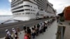 FILE - Passengers disembark from the cruise ship MSC Preziosa, in the Port Area of Rio de Janeiro, Brazil, Jan. 2, 2022, after Brazil confirmed more cases of COVID-19 on board.