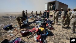 Egyptian soldiers collect personal belongings of plane crash victims at the crash site of a passenger plane bound for St. Petersburg in Russia that crashed in Hassana, Egypt's Sinai Peninsula, Nov. 2, 2015.