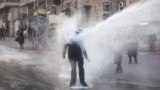 An ultra-Orthodox Jew gets hit by a police water canon during a protest against Israeli army conscription, in Jerusalem.