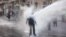 An ultra-Orthodox Jew gets hit by a police water canon during a protest against Israeli army conscription, in Jerusalem.