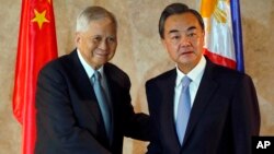 Chinese Foreign Minster Wang Yi (R) is greeted by Philippine Foreign Secretary Albert Del Rosario upon arrival at the Department of Foreign Affairs, Nov. 10, 2015, at suburban Pasay city, south of Manila, Philippines.