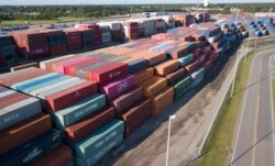 FILE - China Shipping Company and other containers are stacked at the Virginia International's terminal in Portsmouth, Va., May 10, 2019.