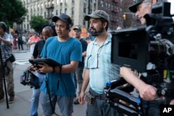 This image released by Warner Bros. Pictures shows director John Chu, left, and Lin-Manuel Miranda on the set of "In the Heights."