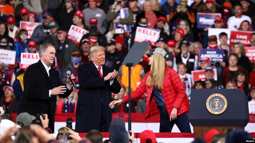 Presiden AS Donald Trump bertepuk tangan saat ia kampanye dengan Senator Republik AS David Perdue (kiri) dan Kelly Loeffler (kanan) di Bandara Regional Valdosta di Valdosta, Georgia, AS, 5 Desember 2020. (Foto: REUTERS/Dustin Chambers)