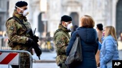 Italijanski vojnici sa medicinskim maskama na trgu Duomo, u Milanu, 24. februara 2020. Najmanje 190 ljudi u severnoj Italiji bilo je pozitivno na testu na COVID-19 virus, a četvoro je preminulo. (Foto: AP)