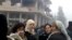 From a Youtube screen grab, image shows women standing next to the site of an explosion in the Syrian town of Salamiah, northeast of Damascus, January 21, 2013.