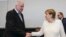 German Chancellor Angela Merkel, right, shakes hands with Interior Minister Horst Seehofer, left, as they arrive for a special faction meeting of the Christian Union parties, ahead of a debate at the German parliament in Berlin, July 3, 2018.