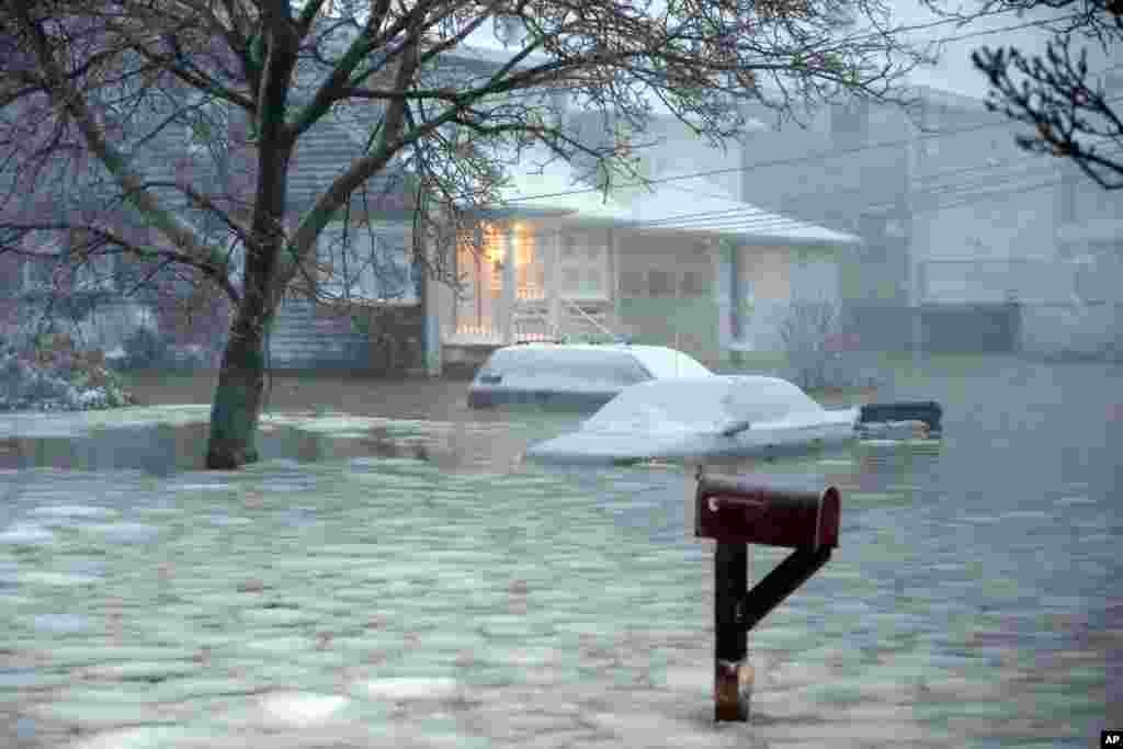 Water floods a street on the coast in Scituate, Massachusetts, Jan. 27, 2015. A storm packing blizzard conditions spun up the East Coast, pounding parts of coastal New Jersey northward through Maine with high winds and heavy snow.