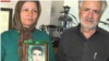 تصویری از پدر و مادر سعید زینالی که عکسی از فرزند خود را در دست دارند