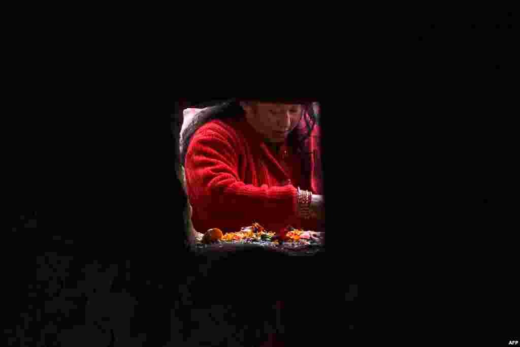 A Hindu woman offers prayers on the banks of the Shali River on the outskirts of Kathmandu, Nepal, as Hindu devotees across the country marked the Swasthani Brata Katha festival.