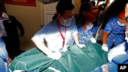 Hospital staff members carry the body of a Caucasian female to a hospital morgue in Seremban, Negeri Sembilan, Malaysia, Aug. 13, 2019. 