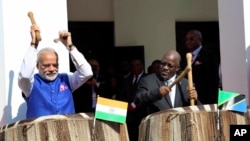 Waziri Mkuu wa India Narendra Modi, kushoto, na mwenyeji wake Rais John Pombe Magufuli, right, beat drums at the entrance of State House during an official welcome ceremony for Modi in Dar es Salaam Tanzania, July 10, 2016. 