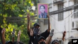 1일 미얀마 양곤에서 군부 쿠데타 반대 시위대가 저항을 상징하는 세 손가락과 아웅산수치 국가고문의 초상화를 들고 있다.