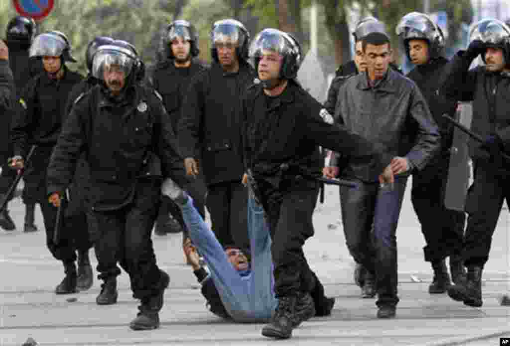 Riot police officers detain a protestor during clashes in Tunis,14 Jan 2011.