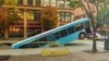 Front of a public bus sticks out of a sinkhole on 10th and Penn Avenue in Pittsburgh, Pennsylvania, U.S., October 28, 2019 in this picture obtained from social media, October 28, 2019. 