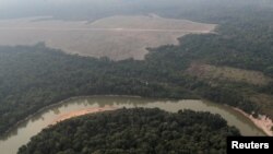 FILE - Aerial view shows a river and a deforested plot of the Amazon near Porto Velho, Rondonia State, Brazil, Aug. 14, 2020. 
