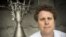 FILE - Rocket Lab CEO Peter Beck poses alongside a Rutherford rocket engine in Auckland, New Zealand, Oct. 20, 2015. 