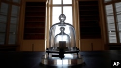 In this photo taken Wednesday, Oct. 17, 2018., a replica of the International Prototype Kilogram is pictured at the International Bureau of Weights and Measures, in Sevres, near Paris. (AP Photo/Christophe Ena)