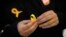 A supporter of Junts per Catalunya or Together for Catalonia makes a yellow ribbon in support of Catalonian politicians who have been jailed on charges of sedition, during a campaigning event in Barcelona, Spain, Dec. 19, 2017. 
