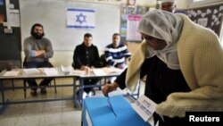 A Druze woman casts her ballot for the parliamentary election at a polling station in the northern Druze-Arab village of Maghar, Israel, January 22, 2013. 