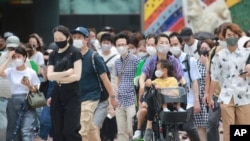 지난 9일 일본 도쿄 시민들이 신종 코로나바이러스 감염 예방 마스크를 쓰고 시내 거리를 걷고 있다. 