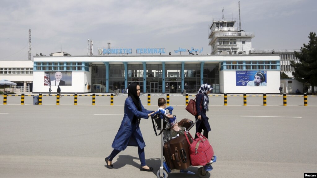 资料照片:阿富汗乘客从喀布尔的哈米德·卡尔扎伊国际机场前走过。(2016年3月29日) (photo:VOA)