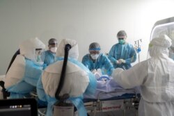 Doctors and ICU nurses wearing personal protection equipment (PPE) perform a CT scan for a COVID-19 patient at the King Chulalongkorn Memorial Hospital in Bangkok, Thailand, April 23, 2020.