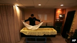 FILE - A funeral home employee prepares a coffin at a mortuary in Taipei, Taiwan, Jan. 16, 2010. A new law that bars news media from disclosing various types of information about suicides is stirring debate in Taiwan.