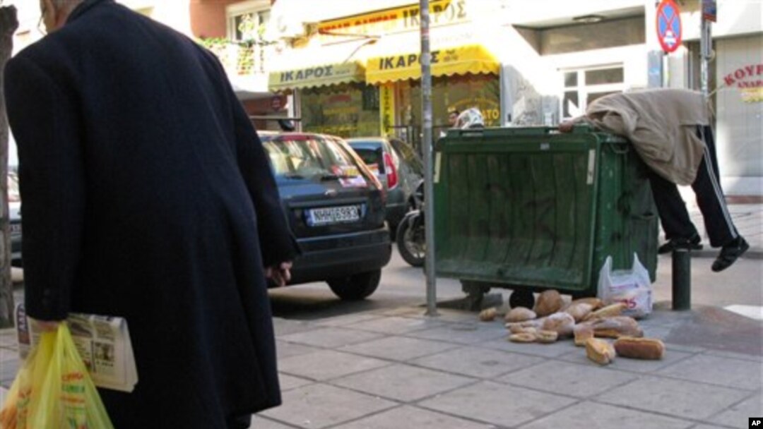 Čovek u Solunu vadi hleb iz kontejnera za smeće 