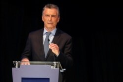 FILE - Argentina presidential candidate Mauricio Macri adjusts his microphone at a presidential debate, ahead of the Oct. 27 presidential election, at the Litoral University in Santa Fe, Argentina, Oct. 13, 2019.