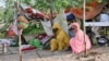 (FILE) People stranded in an inundated area in Tokar in the Red Sea State following recent heavy flooding in eastern Sudan, sit in front of their tent on September 5, 2024.