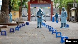 Petugas kesehatan menyemprotkan disinfektan di Hanoi, Vietnam (31/3). 